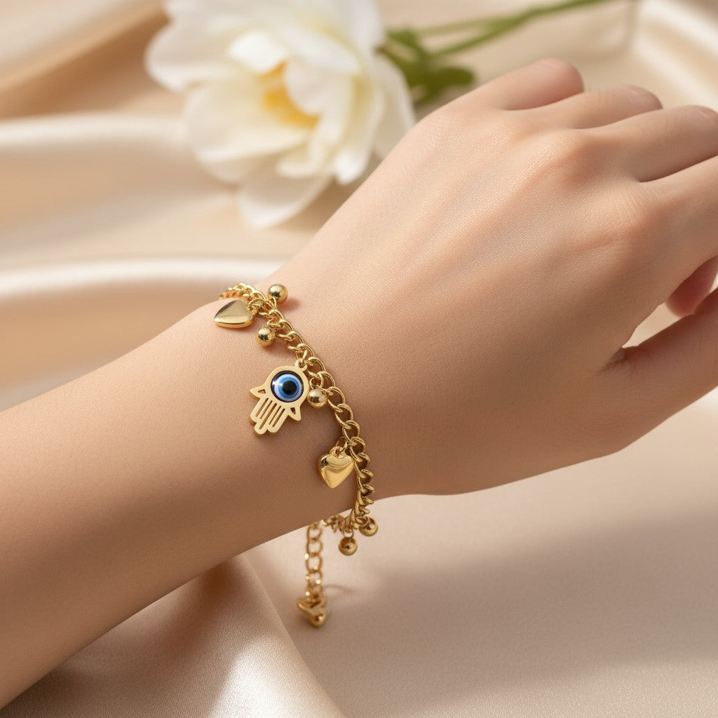 Gold bracelet with charms on a wrist against a soft background