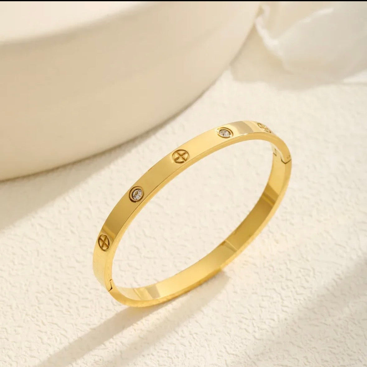 Gold bracelet with diamond accents on a light background
