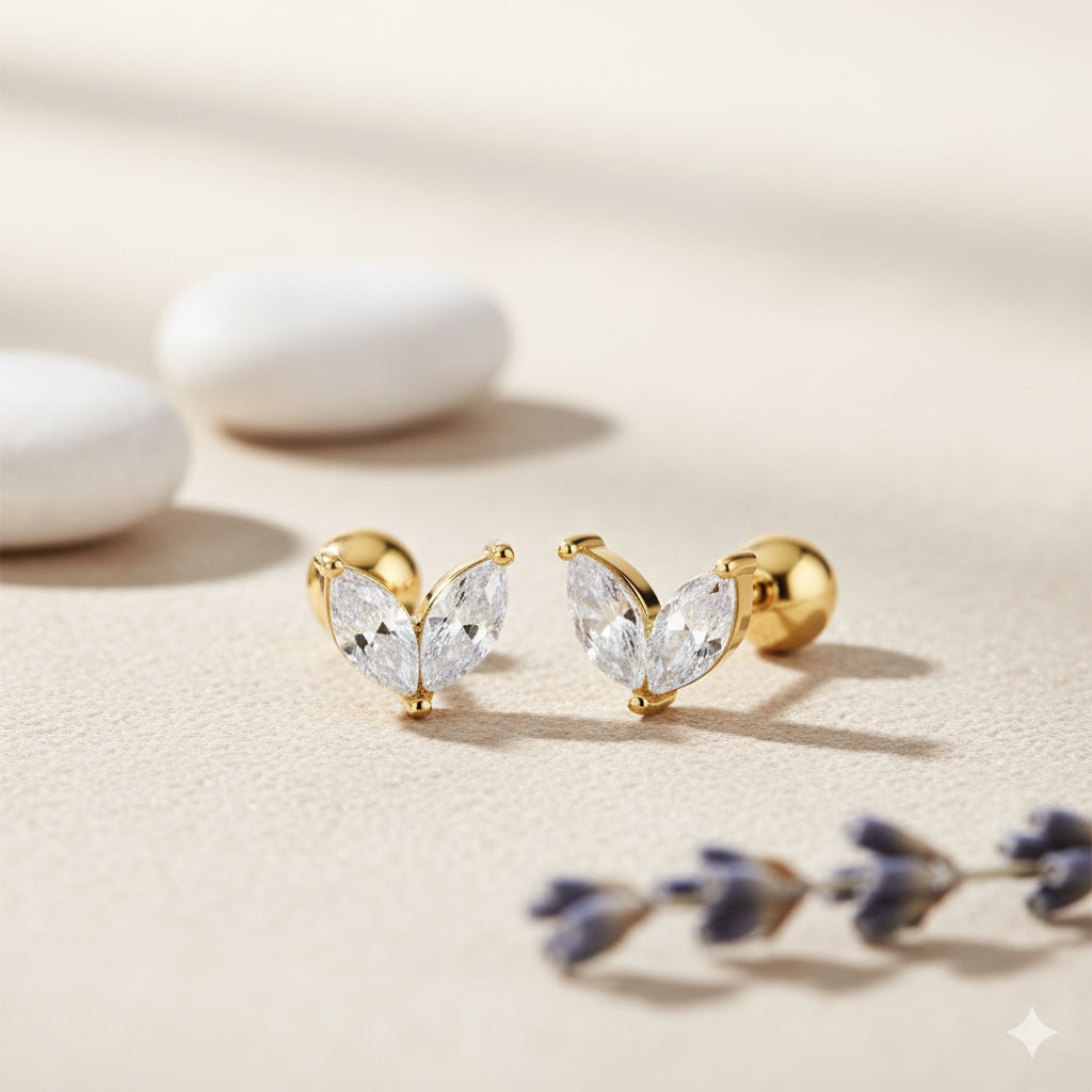 Gold earrings with clear gemstones on a light background