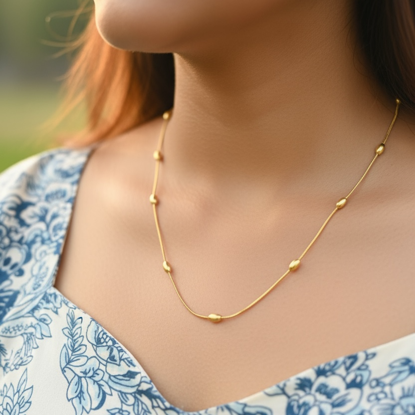Close-up of a woman wearing a gold necklace with a blurred background