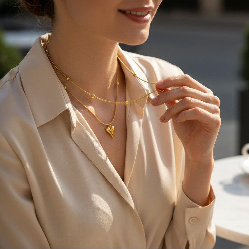 Woman wearing gold necklaces with a blurred outdoor cafe setting