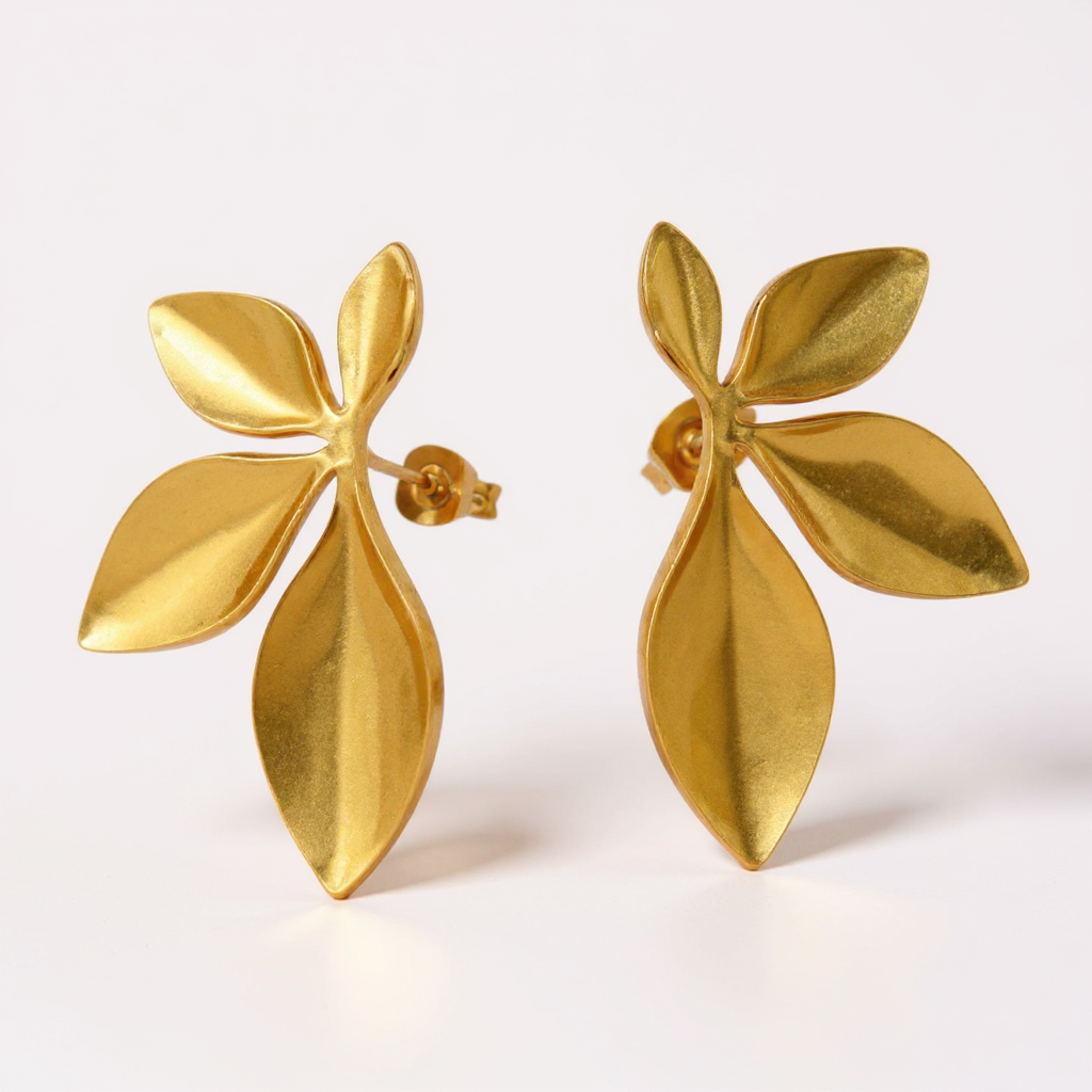 Gold leaf-shaped earrings on a white background