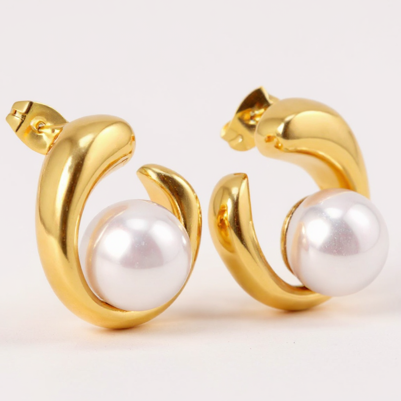 Gold hoop earrings with pearls on a white background