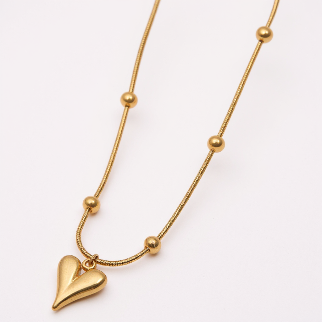 Gold necklace with a heart pendant on a white background