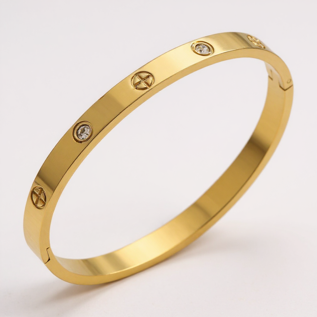 Gold bracelet with diamond accents on a light gray background