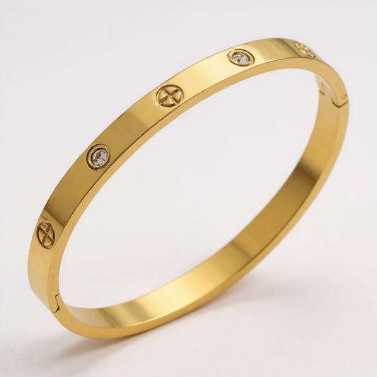 Gold bracelet with diamond accents on a light gray background